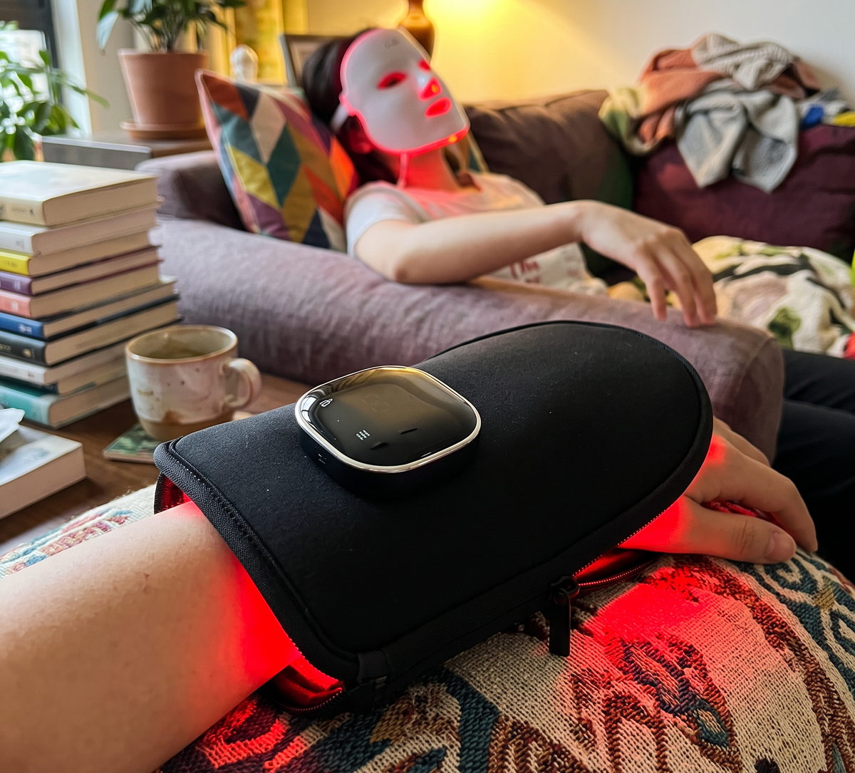The device open and lit on a table beside a mug